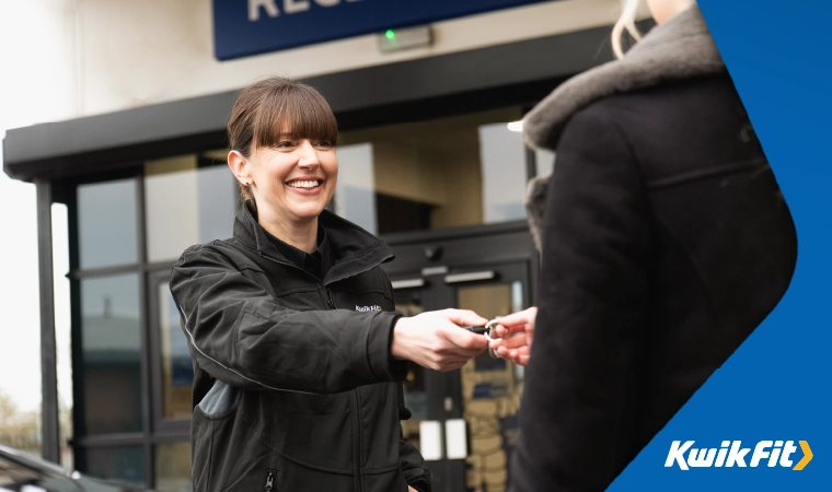Kwik Fit technician handing a customer their keys.