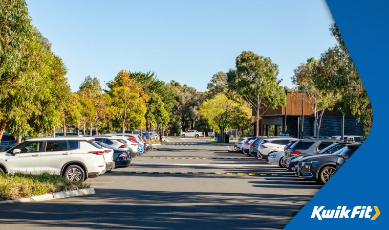 rows of cars in a car park with speed bumps